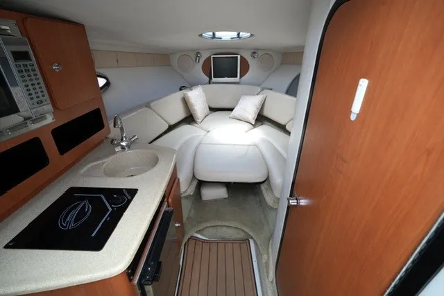 Slide: The Image of 2008 Crownline 250 CR cabin interior with kitchenette, seating, and modern amenities. - 16