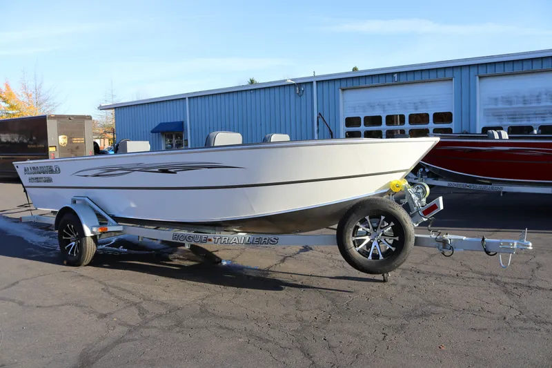 Slide: The Image of 2027 Alumaweld Adventurer 20 boat on Rogue trailer, parked outside a blue building. - 3