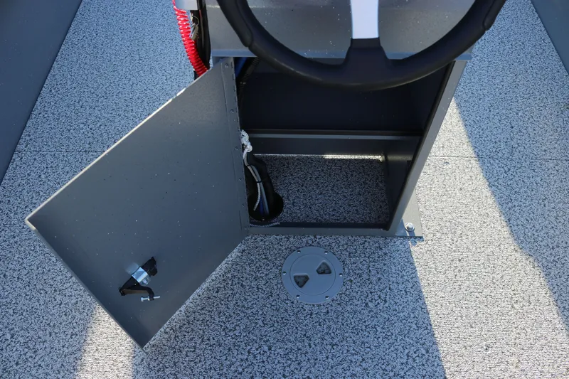 Slide: The Image of 2027 Alumaweld Adventurer 20 boat interior with open storage compartment and steering wheel. - 7