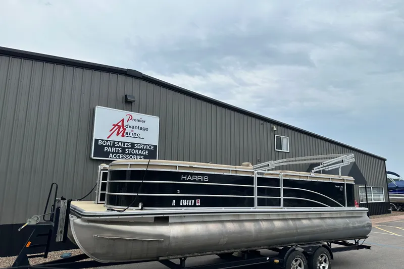 The Image of 2016 Harris Cruiser 240 pontoon boat on trailer at marine dealership. - 0