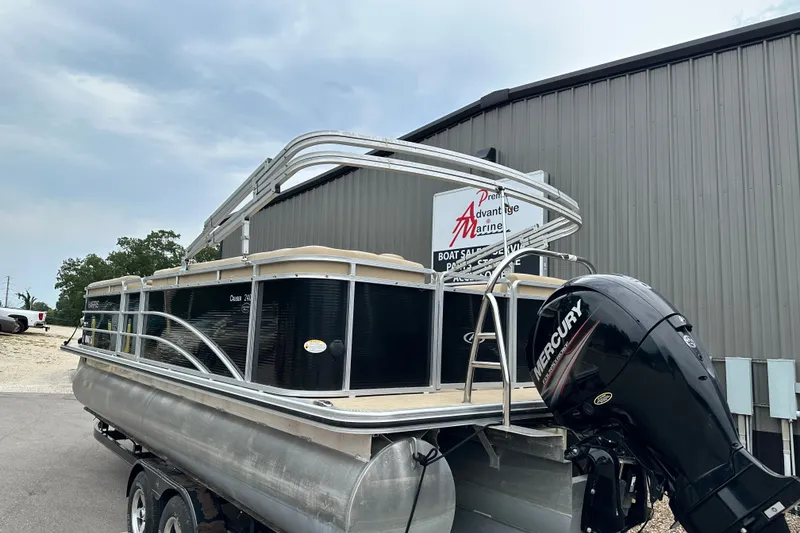 Slide: The Image of 2016 Harris Cruiser 240 pontoon boat with Mercury engine, parked outside a marine dealership. - 3