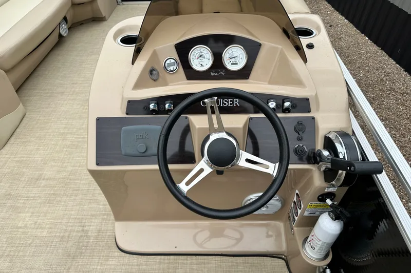 Slide: The Image of Steering console of a 2016 Harris Cruiser 240 pontoon boat with gauges and controls. - 11