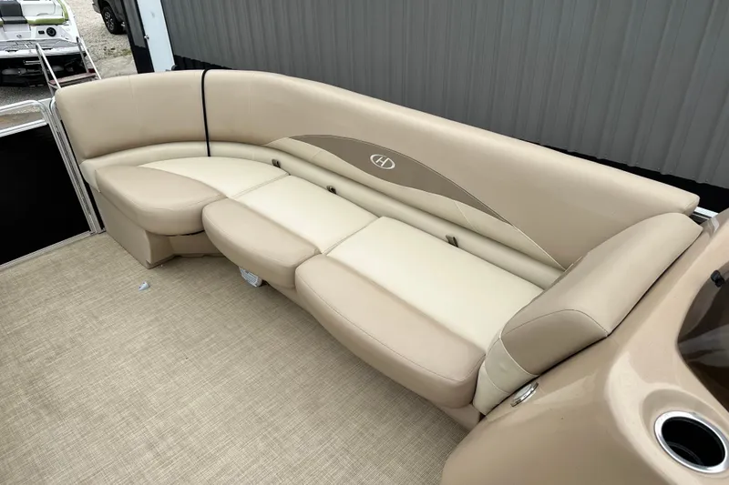 Slide: The Image of 2016 Harris Cruiser 240 boat interior with beige seating and cup holder. - 8