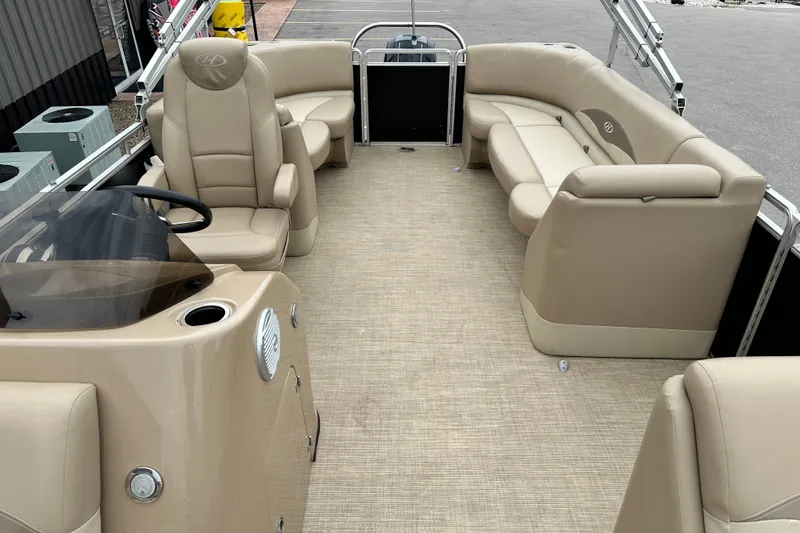 Slide: The Image of 2016 Harris Cruiser 240 pontoon boat interior with beige seating and helm. - 9