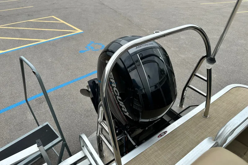 Slide: The Image of 2016 Harris Cruiser 240 boat with Mercury outboard motor in a parking lot. - 4