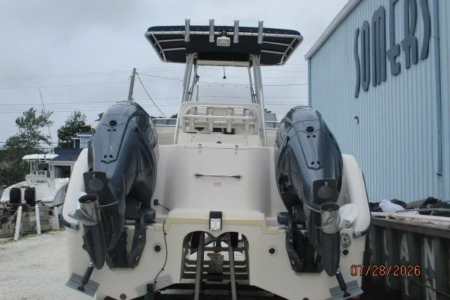Slide: The Image of 2000 Grady-White F-26 Tigercat boat with dual outboard motors, docked near a blue building. - 42