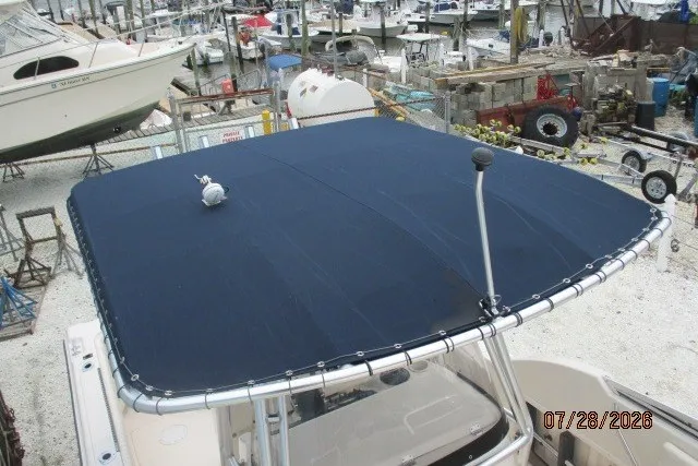 Slide: The Image of 2000 Grady-White F-26 Tigercat boat with a blue canopy in a marina setting. - 8