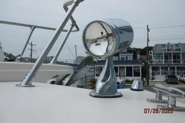 Slide: The Image of Chrome spotlight on 2000 Grady-White F-26 Tigercat boat deck, coastal background. - 48
