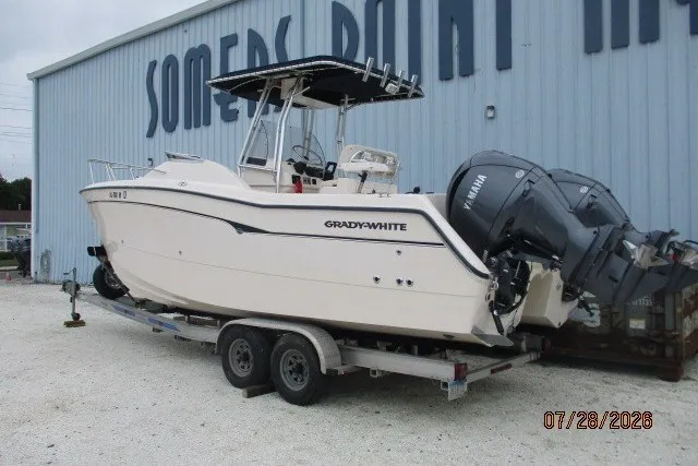 Slide: The Image of 2000 Grady-White F-26 Tigercat boat on trailer, parked outside Somers Point building. - 4