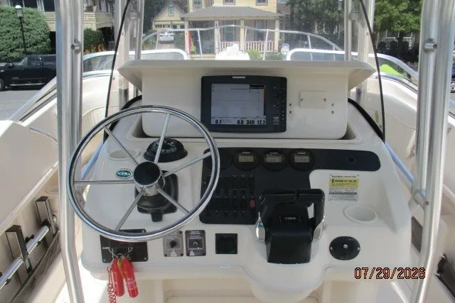 Slide: The Image of Grady-White X-26 Tigercat 2000 boat dashboard with steering wheel and navigation controls. - 2