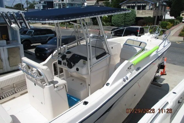 Slide: The Image of 2000 Grady-White X-26 Tigercat boat with T-top and dual console, docked in a marina. - 3