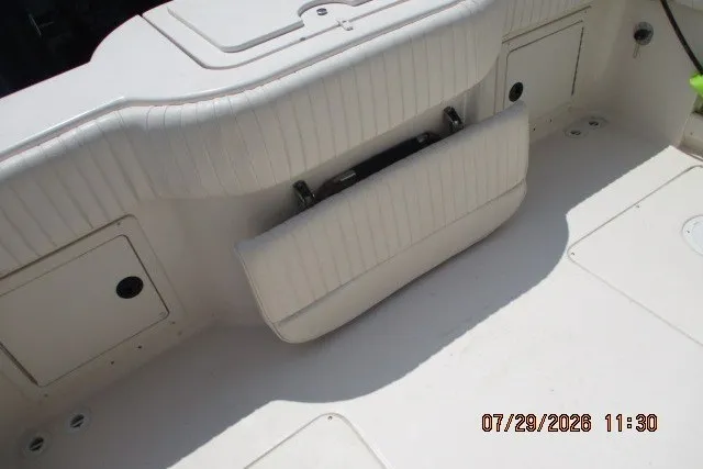 Slide: The Image of 2000 Grady-White X-26 Tigercat boat interior with foldable seat and storage compartments. - 61