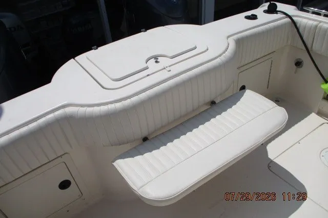 Slide: The Image of 2000 Grady-White X-26 Tigercat boat interior with white seating and storage compartments. - 60