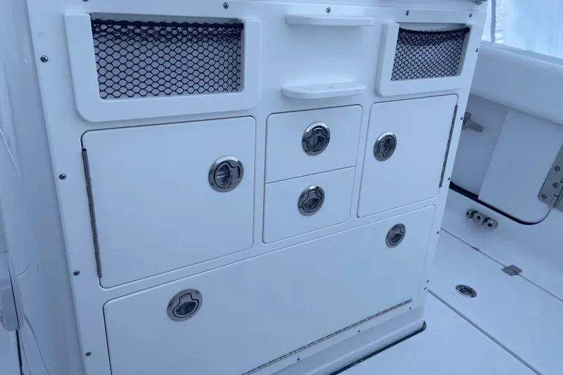Slide: The Image of 2027 Sportsman Open 262 Center Console storage compartments with sleek design and stainless steel handles. - 5