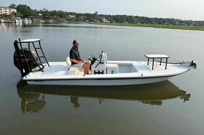 The Image of 2020 Maverick 18 HPX-V boat on calm water with a person seated at the helm. - 0