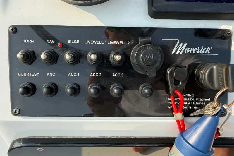 Slide: The Image of Control panel of a 2020 Maverick 18 HPX-V boat with various switches and a 12V outlet. - 40