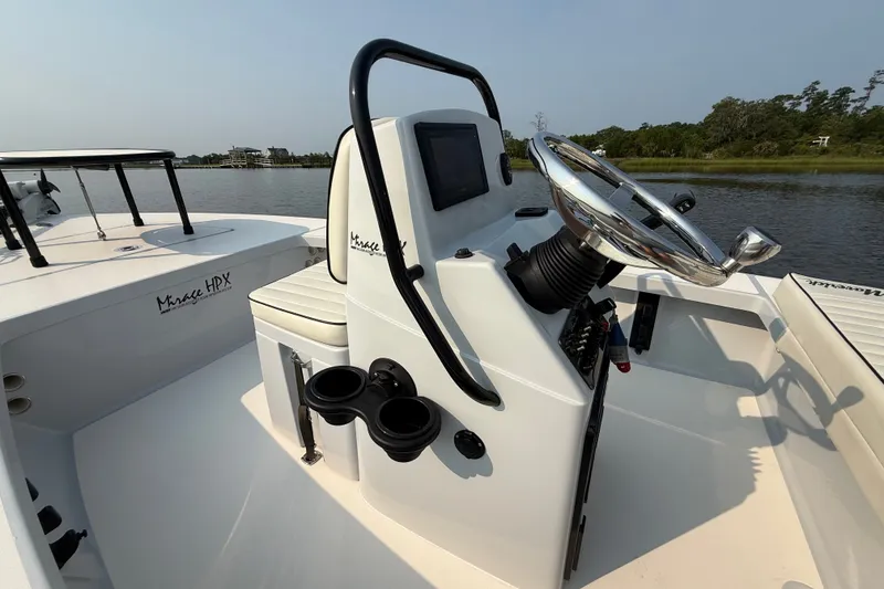 Slide: The Image of 2020 Maverick 18 HPX-V boat interior with steering wheel and console, on calm water. - 22