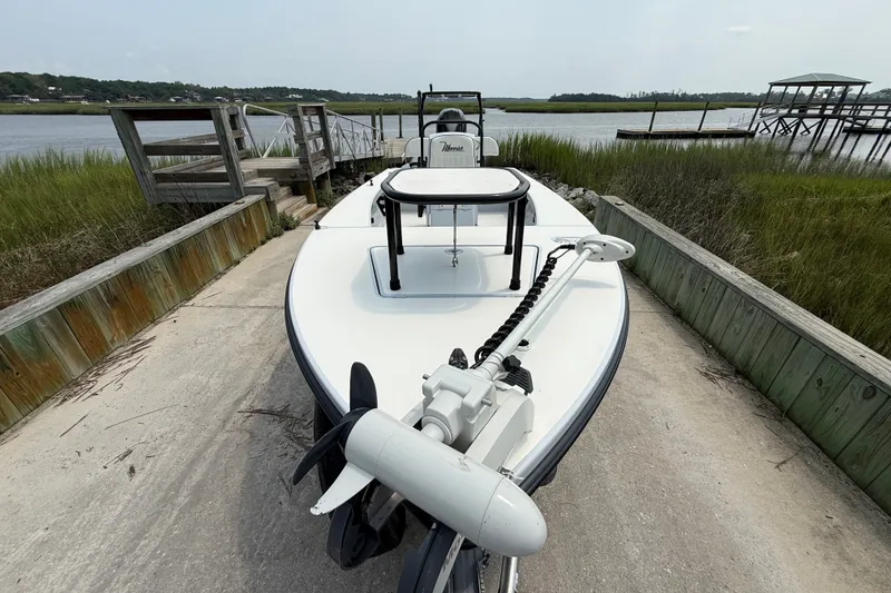 Slide: The Image of 2020 Maverick 18 HPX-V boat docked by a scenic waterfront with lush greenery. - 10