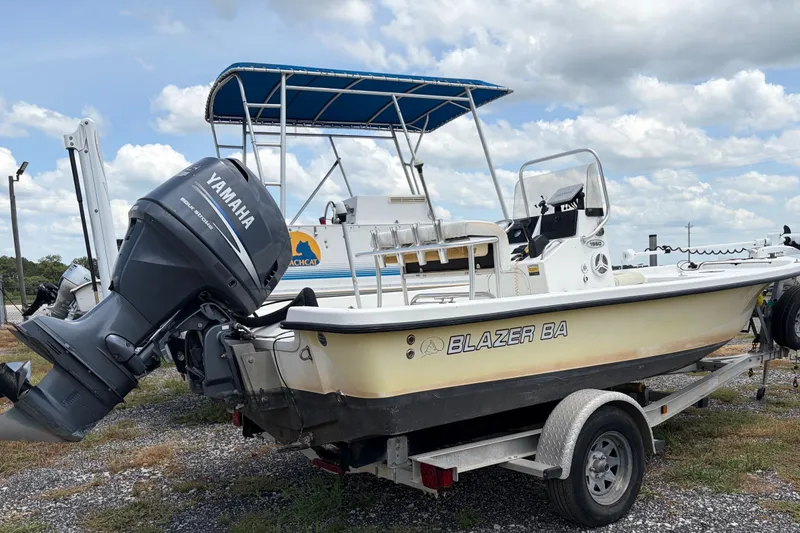 Slide: The Image of 2008 Blazer Bay 1960 boat with Yamaha engine on trailer, under blue sky. - 2