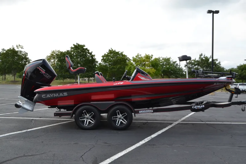 Slide: The Image of 2021 Caymas CX 19 boat in parking lot, red and black design, on trailer. - 2