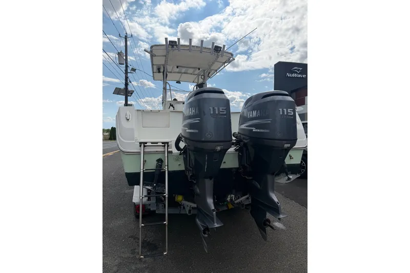 Slide: The Image of 2007 Sailfish 2360 CC boat with twin Yamaha 115 engines, parked outdoors. - 3