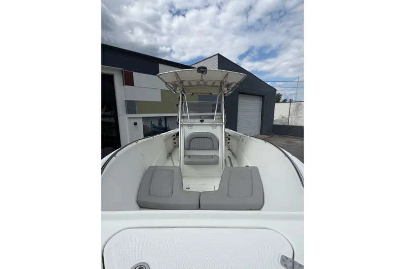 Slide: The Image of 2007 Sailfish 2360 CC boat with cushioned seating, docked outdoors under cloudy skies. - 10