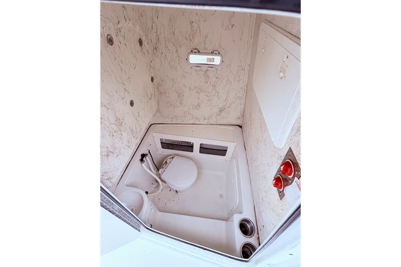 Slide: The Image of Interior of 2007 Sailfish 2360 CC boat bathroom with toilet and storage compartments. - 15