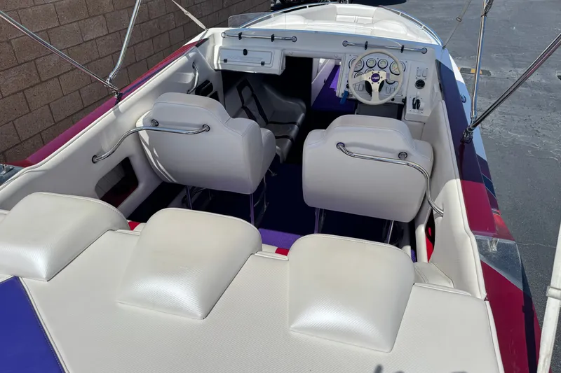 Slide: The Image of Interior of a 2005 Ultimate Warlock 25 World Class boat with white seating and steering wheel. - 8