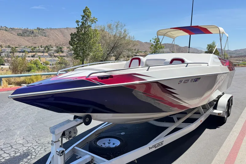 Slide: The Image of 2005 Ultimate Warlock 25 World Class boat on trailer, featuring sleek design and vibrant colors. - 3