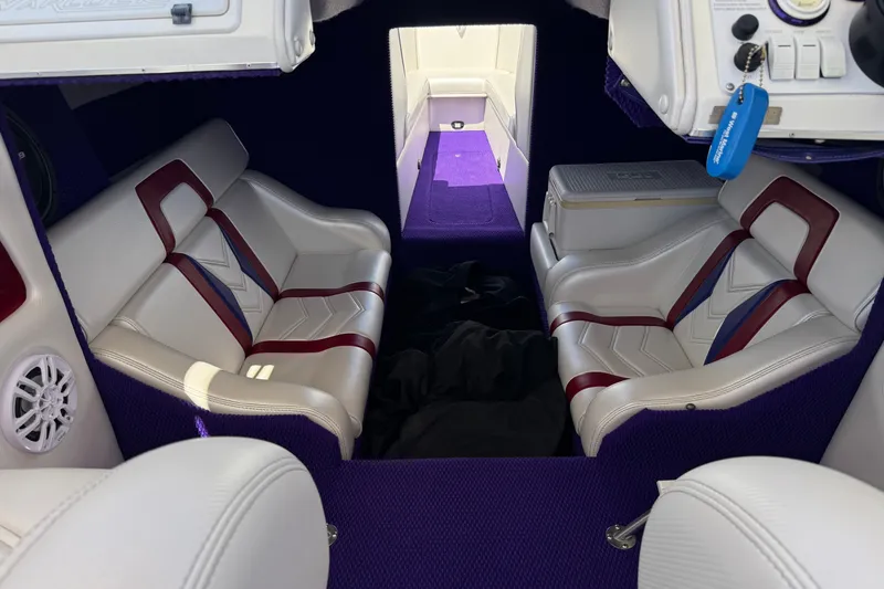 Slide: The Image of Interior of a 2005 Ultimate Warlock 25 World Class boat with purple and white seating. - 12