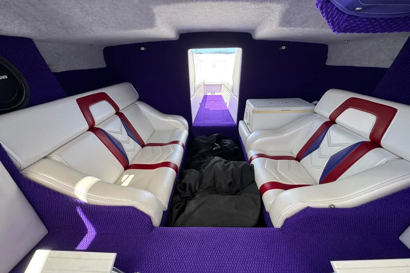 Slide: The Image of Interior of a 2005 Ultimate Warlock 25 World Class boat with purple and white seating. - 13