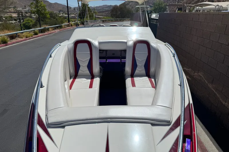 Slide: The Image of 2005 Ultimate Warlock 25 World Class boat with white and red interior, parked on a sunny day. - 9