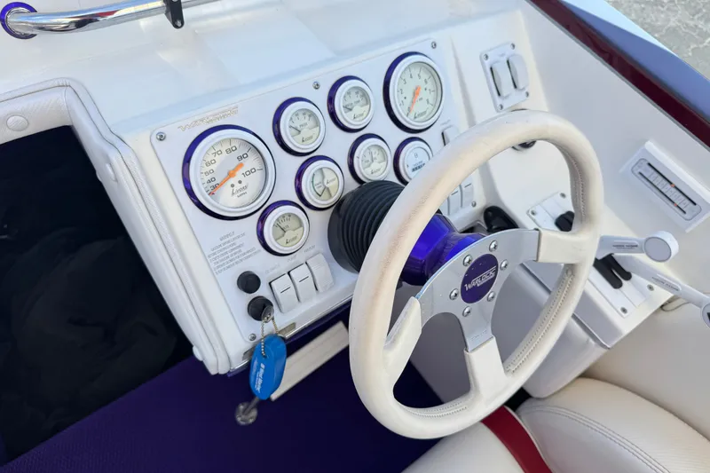 Slide: The Image of Steering wheel and dashboard of a 2005 Ultimate Warlock 25 World Class boat. - 24