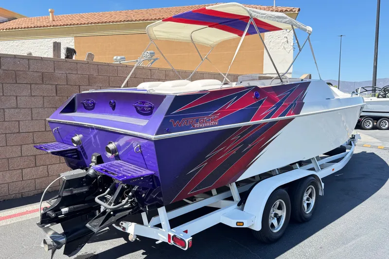 Slide: The Image of 2005 Ultimate Warlock 25 World Class powerboat with vibrant graphics on a trailer. - 5