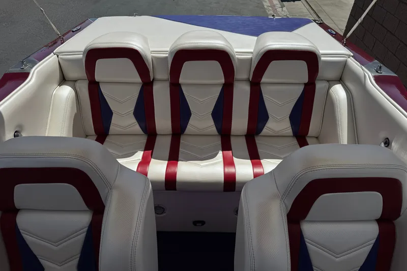 Slide: The Image of Interior seating of a 2005 Ultimate Warlock 25 World Class boat, featuring red and blue accents. - 16