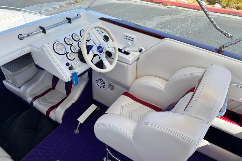Slide: The Image of Interior of a 2005 Ultimate Warlock 25 World Class boat with white seating and control panel. - 22