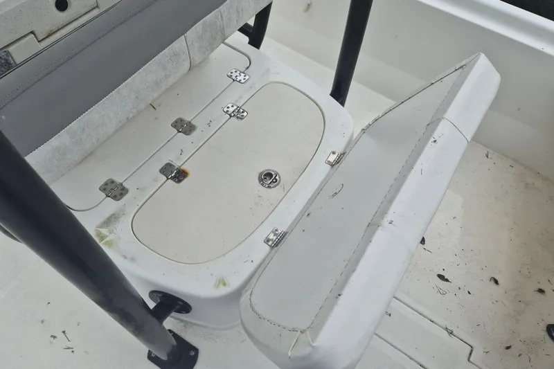 Slide: The Image of 2018 Mako Pro Skiff 19 CC Top Drive boat seat with storage compartment open. - 16