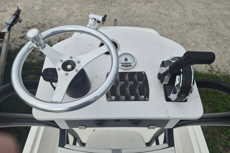 Slide: The Image of 2018 Mako Pro Skiff 19 CC Top Drive console with steering wheel and controls. - 18