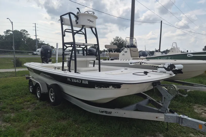 The Image of 2018 Mako Pro Skiff 19 CC Top Drive boat on trailer, parked outdoors. - 1