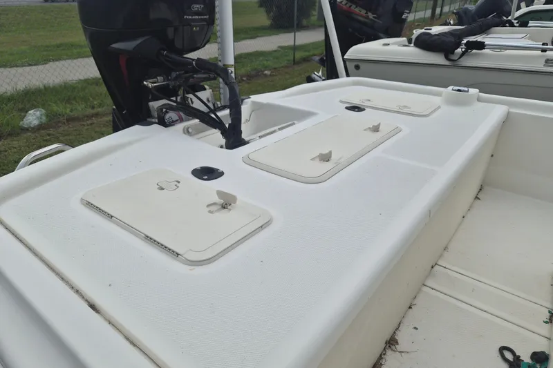 Slide: The Image of 2018 Mako Pro Skiff 19 CC Top Drive boat with storage compartments and outboard motor. - 5