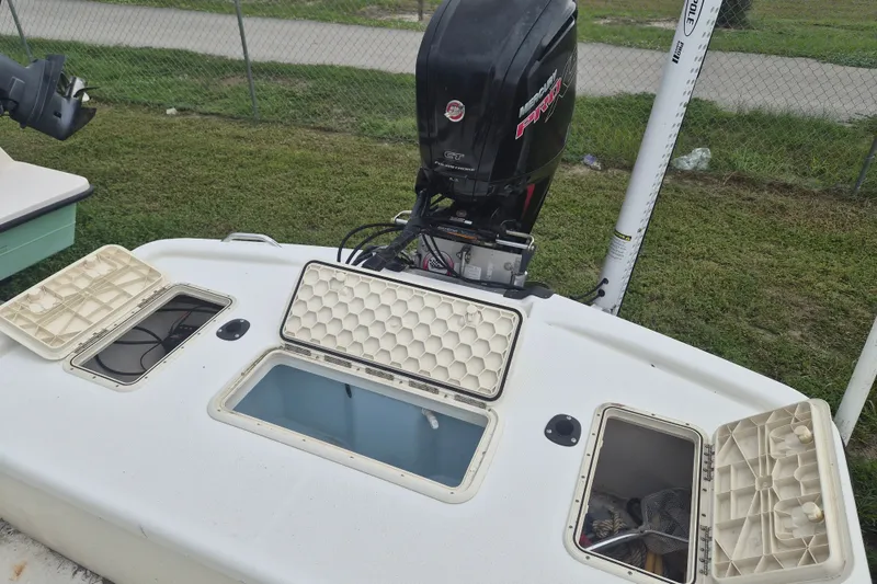 Slide: The Image of 2018 Mako Pro Skiff 19 CC Top Drive boat with open storage compartments and Mercury engine. - 6