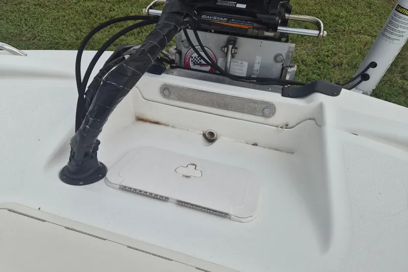 Slide: The Image of 2018 Mako Pro Skiff 19 CC Top Drive boat deck with control cables and hatch. - 7