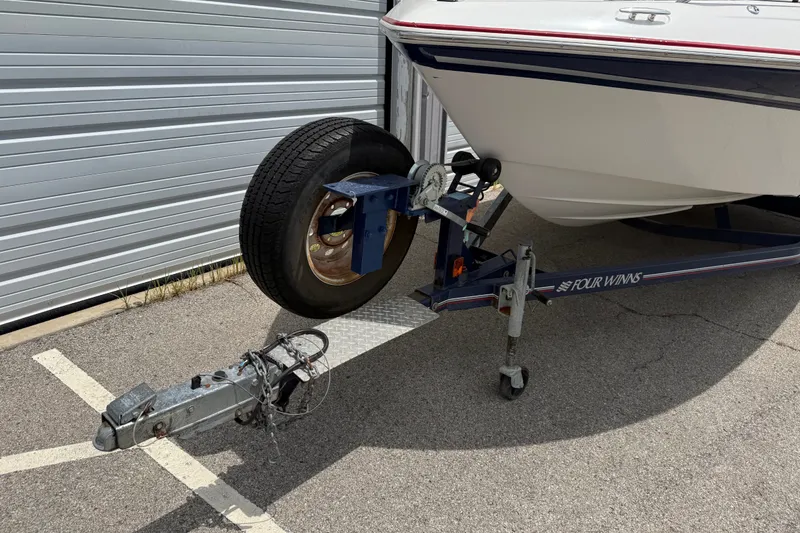 Slide: The Image of 2003 Four Winns 190 Horizon boat on trailer near metal garage door. - 7