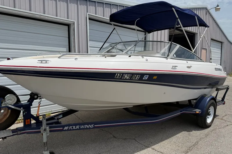 Slide: The Image of 2003 Four Winns 190 Horizon boat on trailer, parked outside a garage. - 6