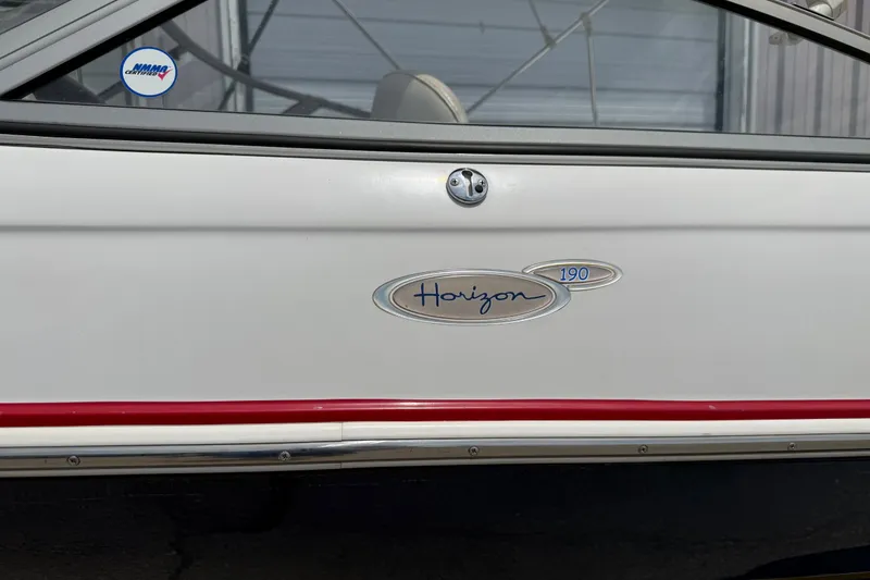 Slide: The Image of 2003 Four Winns 190 Horizon boat emblem on white exterior with red trim. - 5