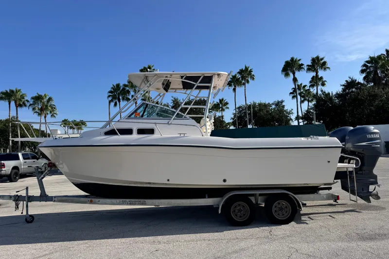 Slide: The Image of 2004 Grady-White Gulfstream 232 boat on trailer, parked outdoors with palm trees. - 7