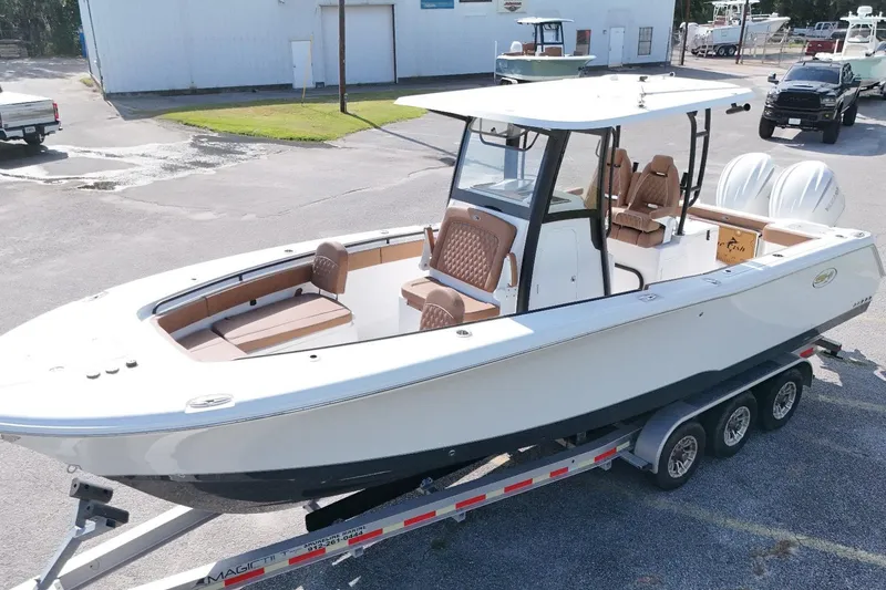 Slide: The Image of 2027 Sea Hunt Gamefish 28 Forward Seating boat on trailer, featuring dual engines. - 12