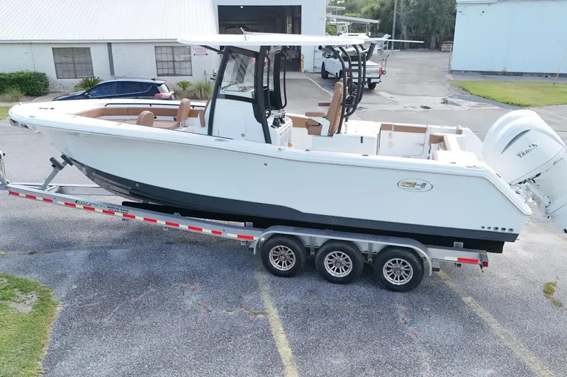 Slide: The Image of 2027 Sea Hunt Gamefish 28 Forward Seating boat on trailer, parked outdoors. - 7