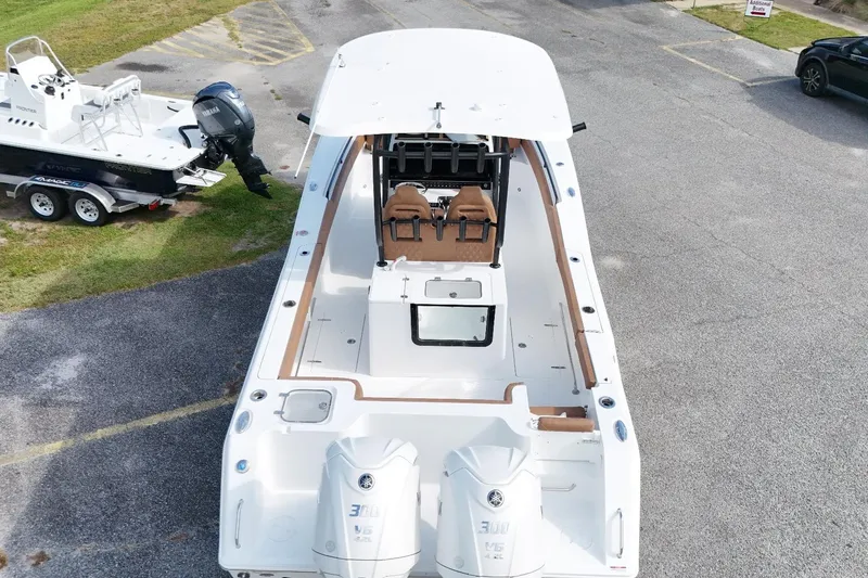 Slide: The Image of 2027 Sea Hunt Gamefish 28 Forward Seating boat with dual Yamaha engines, parked on pavement. - 2
