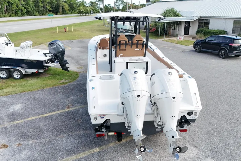Slide: The Image of 2027 Sea Hunt Gamefish 28 with dual Yamaha engines, parked outdoors. - 9